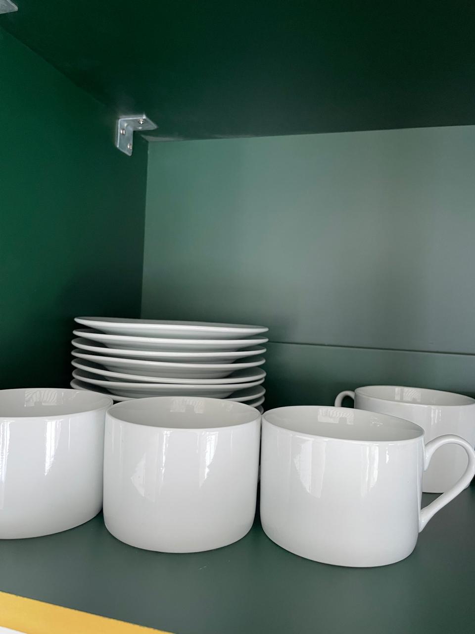 White porcelain mugs and matching side plates for tea and coffee