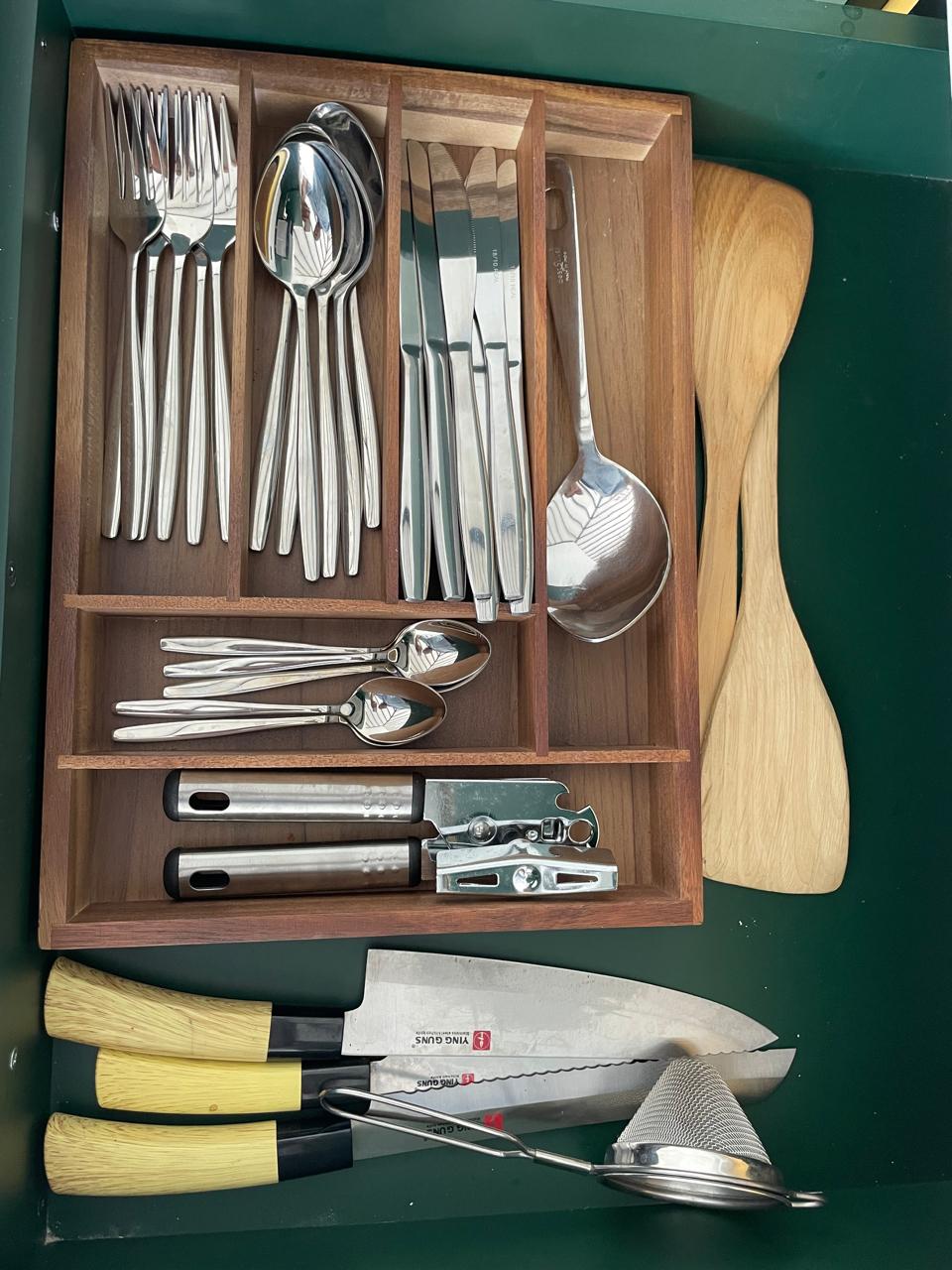 Drawer of matching stainless-steel cutlery, serving spoons, knives and kitchen utensils