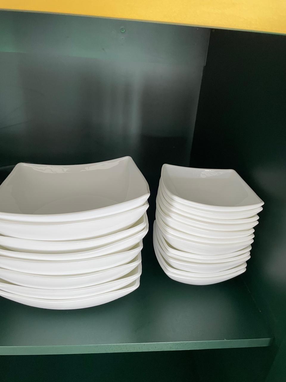 White square dinner plates provided in the kitchen cupboard