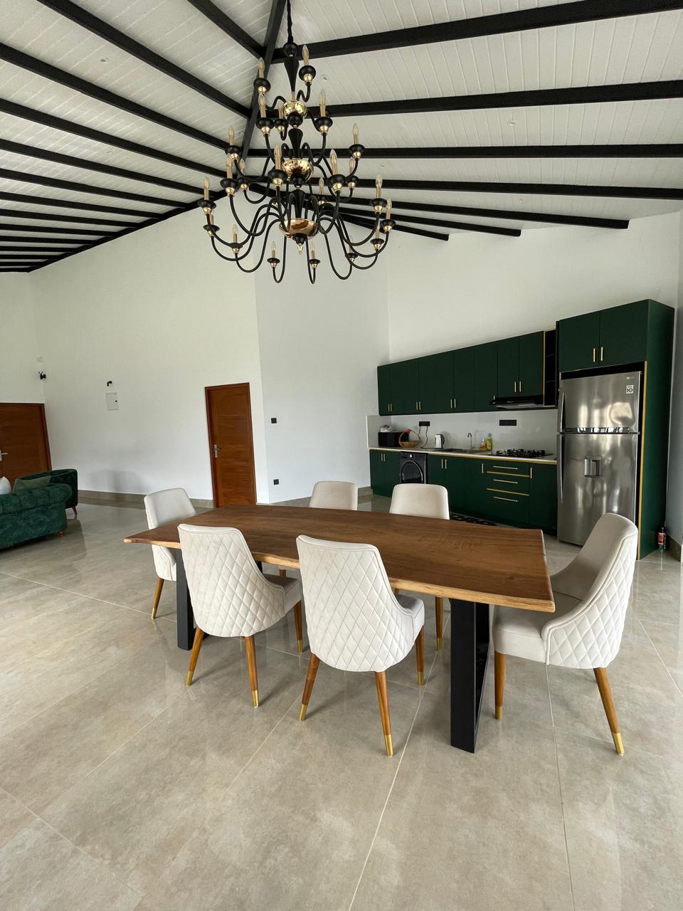 Close view of the live-edge dining table seating eight, with the lounge beyond