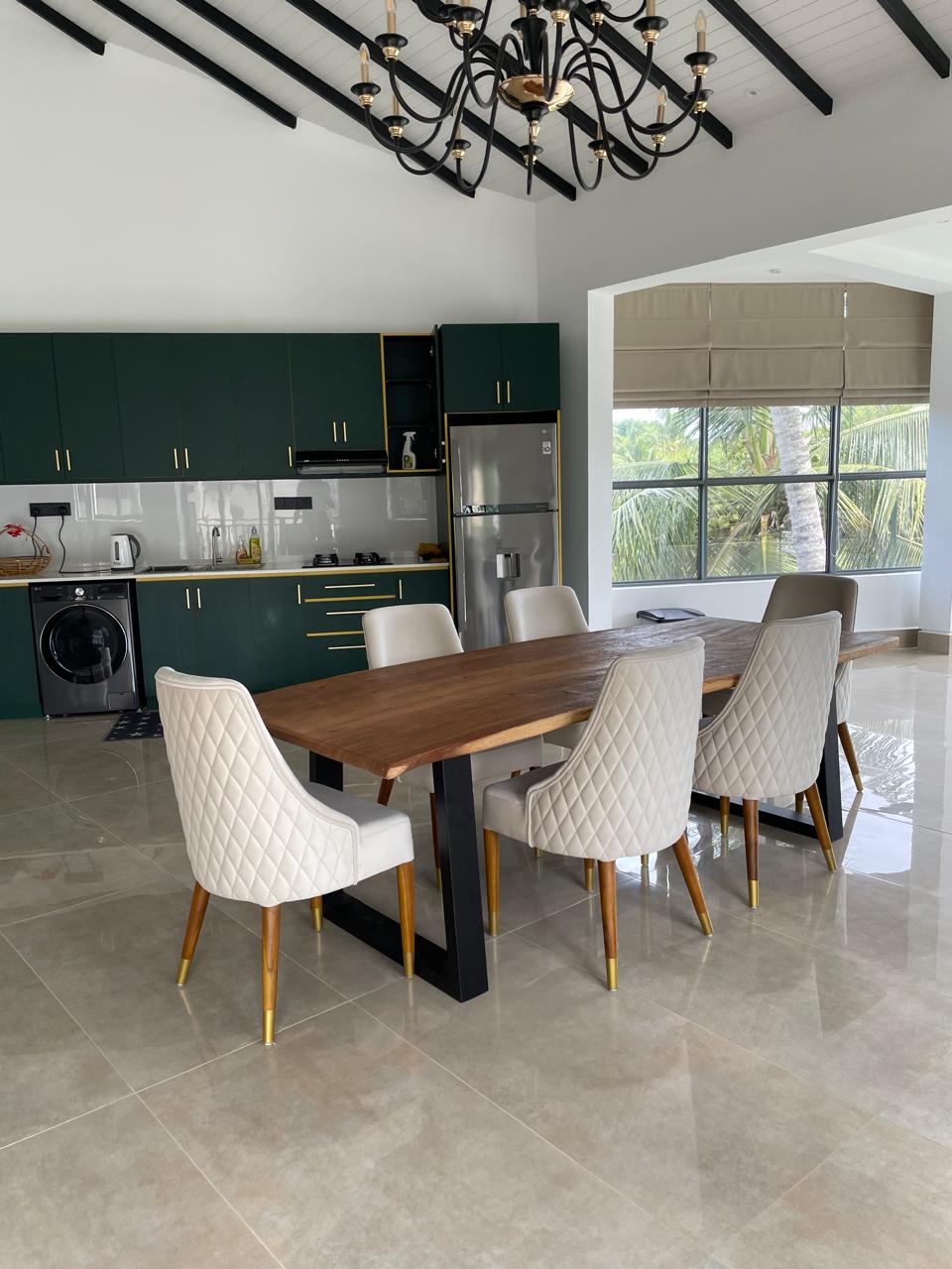 Close view of the live-edge dining table seating eight, with the lounge beyond